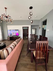 a living room with a couch and a table and a tv at Sea View Apartment in Colombo