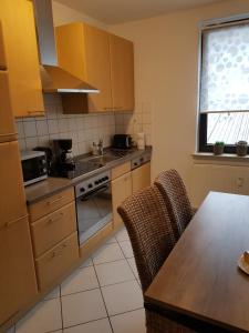 a kitchen with wooden cabinets and a table with chairs at Übernachten im Herzen des Ruhrpotts in Bochum
