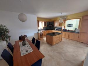 a kitchen with a wooden table and a table and chairs at Grand & Cozy apartment on great location, central in Is-Swieqi