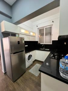 a kitchen with a refrigerator and a washing machine at Sea View Apartment in Colombo
