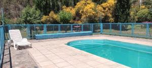 a chair sitting next to a swimming pool at La flor del lugar in Potrerillos