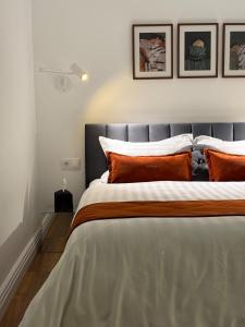 a bedroom with a large bed with orange pillows at Love&Loft central park with private garden in Baia Mare