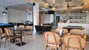 a restaurant with tables and chairs and a pool table at Desa Phuket in Phuket