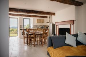 a living room with a couch and a table and a kitchen at Pied à Terre in Bain-de-Bretagne