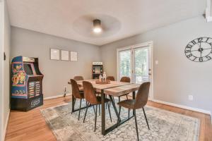 una sala da pranzo con tavolo, sedie e orologio di Spacious Home with 3 King Beds, Arcades and 86 inch TV a Snellville