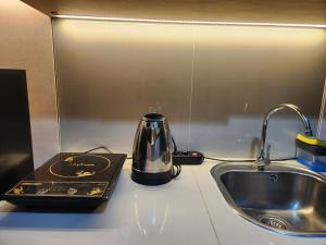 a tea kettle sitting on a counter next to a sink at Cozy Studio Apartement South Surabaya in Surabaya