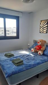 a teddy bear sitting on top of a bed at Costa Blanca Suit in Arenales del Sol +3 photos
