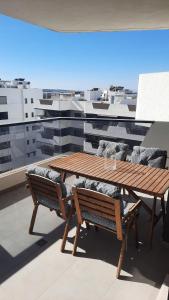 a wooden table and chairs on top of a balcony at Costa Blanca Suit in Arenales del Sol