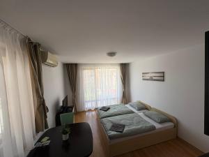 Un pequeño dormitorio con una cama y una mesa. en Private Apartment 171 in Prestige Fort Beach Hotel, en Sveti Vlas 35 fotos más
