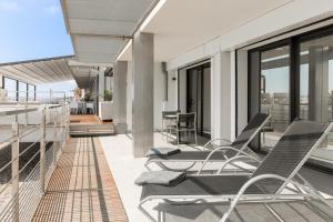 an outdoor patio with chairs and tables on a balcony at Villa Azur in Villeneuve-Loubet