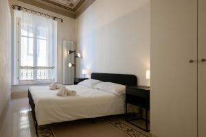 a bedroom with a bed with white sheets and a window at Casa San Felice in Pisa