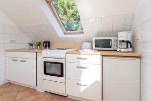 a kitchen with white appliances and a window at Arne&#039s Koje in Fehmarn