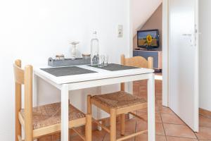a kitchen with a white table and chairs at Arne&#039s Koje in Fehmarn