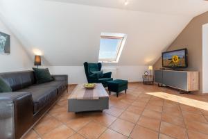 a living room with a couch and a tv at Arne&#039s Koje in Fehmarn