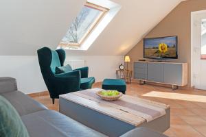 a living room with a couch and chairs and a tv at Arne&#039s Koje in Fehmarn +17 photos