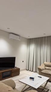 ein Wohnzimmer mit einer Couch, einem Fernseher und einem Tisch in der Unterkunft Luxury Apartment for Rent Summer in Quai