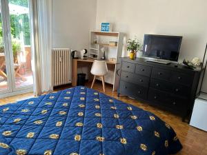 ein Schlafzimmer mit einem Bett, einer Kommode und einem Fernseher in der Unterkunft Vito's Room in Cormano