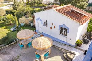 an aerial view of a house with two tables and umbrellas at Santa Cruz Surf House by Stoke Travel in A dos Cunhados