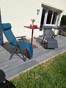 a blue chair and a table on a patio at Ô Charme de St Ô in Saint-Omer +29 photos
