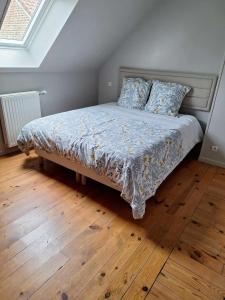 a bed in a bedroom with a wooden floor at Ô Charme de St Ô 4 étoiles in Saint-Omer