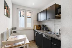 a kitchen with black cabinets and a table and a counter at Ferienwohnung Pfauenhof in Harztor +14 photos