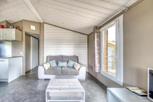 a living room with a couch and a window at Chalet parc nature océan in Hourtin