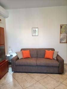 1 sofá marrón con 2 almohadas de color naranja en la sala de estar. en RORY HOUSE - Como, en Como