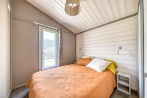 a bed in a room with a window at Chalet parc nature océan in Hourtin +13 photos