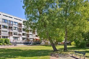 ヴンストルフにあるBella Nova - Steinhudeの建物前のベンチと木のある公園