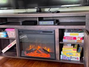 a fireplace in a entertainment center with a tv at The Red Country Cottage in Amenia