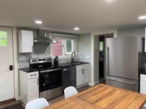 a kitchen with a stove and a refrigerator and a table at The Red Country Cottage in Amenia