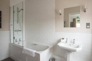 a white bathroom with a sink and a shower at The Swan Hotel in Southwold