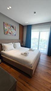 a bedroom with a large bed with blue curtains at King Hotel Ksamil in Ksamil