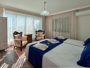 a bedroom with a bed and two chairs and a television at Villa Zeytin in Kusadası +21 photos