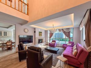 a living room with purple furniture and a dining room at Villa Zeytin in Kusadası