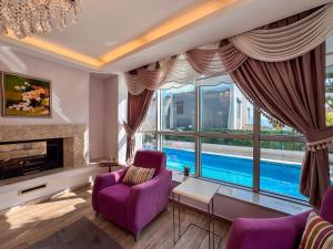 a living room with purple furniture and a large window at Villa Zeytin in Kusadası