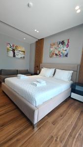 a large white bed in a room with wooden floors at King Hotel Ksamil in Ksamil