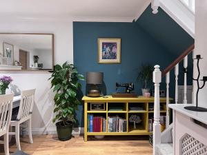 a room with a blue wall and a yellow book shelf at Cosy Georgian Cottage - Parking - Central Frome in Frome