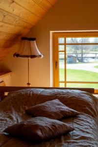 a bedroom with a bed with a lamp and a window at Stadelnieki in Stadelnieki
