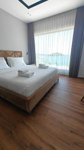 a bedroom with a large bed and a large window at King Hotel Ksamil in Ksamil