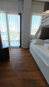 a bedroom with a bed and a laptop on a wooden floor at King Hotel Ksamil in Ksamil