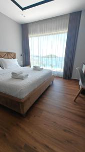 a bedroom with a bed and a large window at King Hotel Ksamil in Ksamil