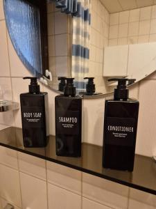 three bottles of soap on a counter in a bathroom at Linnich Apartment für 4 Personen mit Küche in Linnich