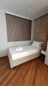 a large bed in a room with wooden floors at King Hotel Ksamil in Ksamil
