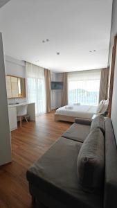 a large room with two beds and a couch at King Hotel Ksamil in Ksamil