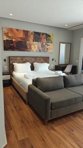 a bedroom with a large bed and a couch at King Hotel Ksamil in Ksamil