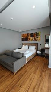 a bedroom with a large bed and a couch at King Hotel Ksamil in Ksamil