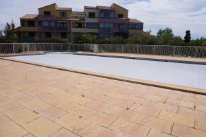 an empty swimming pool in front of a building at Barcarelles avec PISCINE Plage clim 5 personnes in Le Barcarès