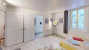 a living room with white walls and a window at Magnifique studio Franklin in Le Havre