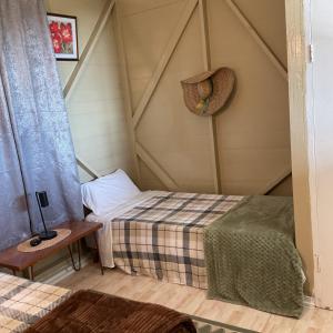 a room with two beds and a hat on the wall at Adella's Blue Mountain Coffee Farmstay in Kingston